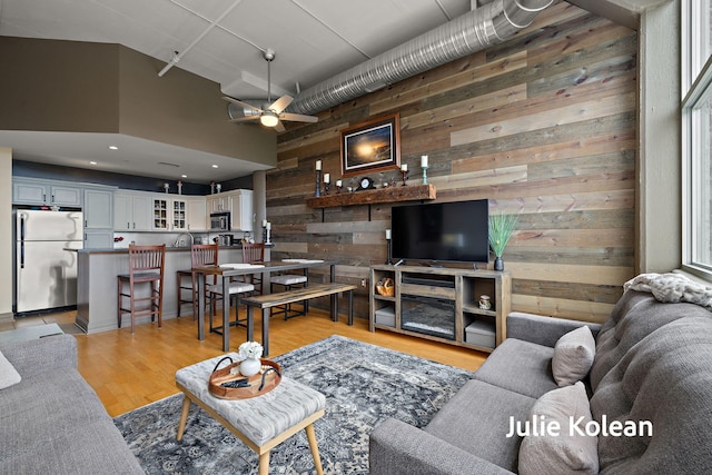 930 Washington Ave Unit 5C, Muskegon, MI 49441 - living room featuring wooden walls, ceiling fan, a high ceiling, light wood finished floors, and recessed lighting