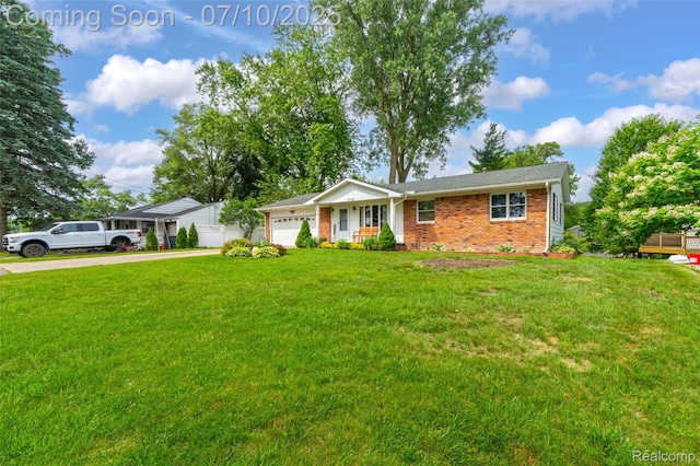 2150 Dunwoodie St, Ortonville, MI 48462 - single story home with concrete driveway, brick siding, a garage, and a front yard