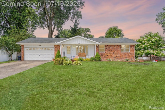 2150 Dunwoodie St, Ortonville, MI 48462 - ranch-style home featuring an attached garage, concrete driveway, brick siding, and covered porch