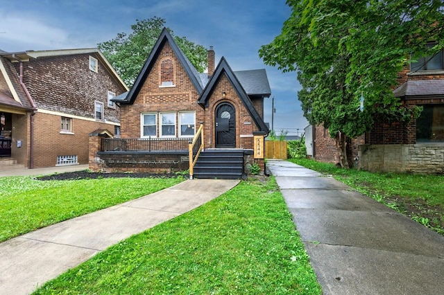 5544 Balfour Rd, Detroit, MI 48224 - tudor-style house with brick siding, a front yard, and a chimney