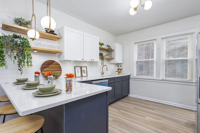 5544 Balfour Rd, Detroit, MI 48224 - kitchen featuring open shelves, a peninsula, light countertops, white cabinets, and a breakfast bar