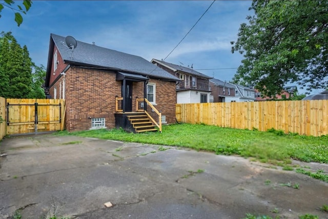 5544 Balfour Rd, Detroit, MI 48224 - rear view of property featuring brick siding, a shingled roof, and a gate
