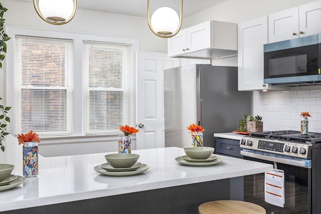 5544 Balfour Rd, Detroit, MI 48224 - kitchen with appliances with stainless steel finishes, tasteful backsplash, light countertops, white cabinets, and pendant lighting