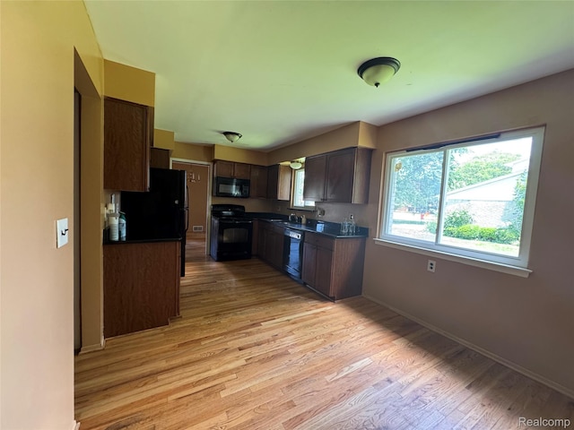 28330 Lahser Rd, Southfield, MI 48034 - kitchen with black appliances, light wood finished floors, dark countertops, and dark brown cabinetry