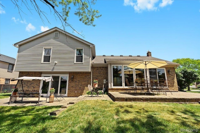 20213 Whitby Dr, Livonia, MI 48152 - rear view of house with brick siding, a patio area, and a lawn