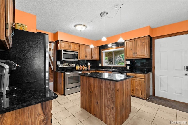 20213 Whitby Dr, Livonia, MI 48152 - kitchen with appliances with stainless steel finishes, brown cabinets, light tile patterned flooring, and a textured ceiling
