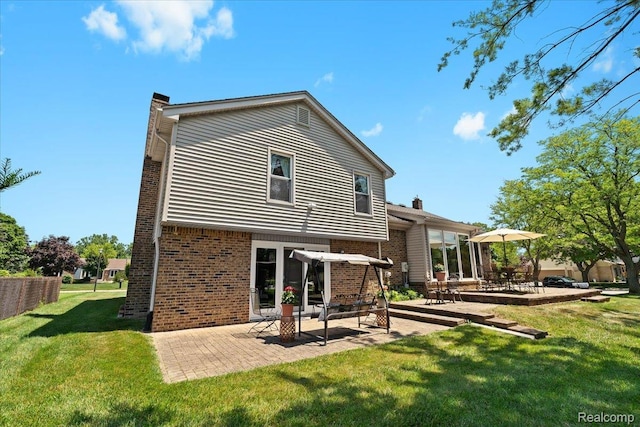 20213 Whitby Dr, Livonia, MI 48152 - back of house featuring a chimney, a patio, brick siding, and a yard