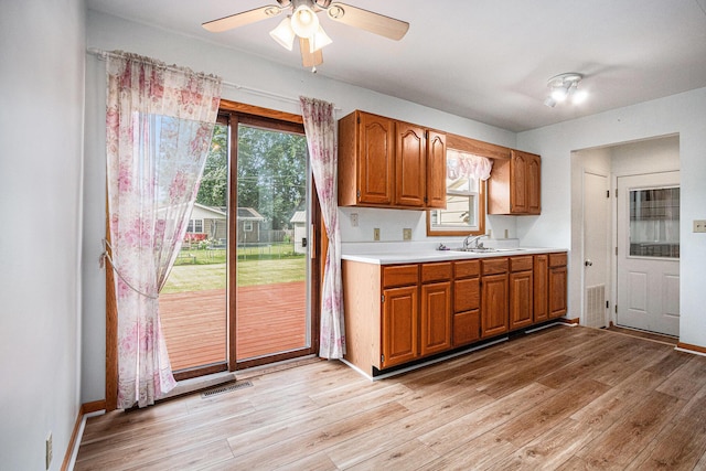 981 Vinewood Dr, Saint Joseph, MI 49085 - kitchen with light countertops, brown cabinetry, a ceiling fan, and light wood finished floors