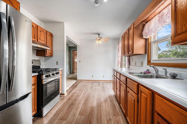 981 Vinewood Dr, Saint Joseph, MI 49085 - kitchen with appliances with stainless steel finishes, under cabinet range hood, brown cabinets, and light wood-style floors