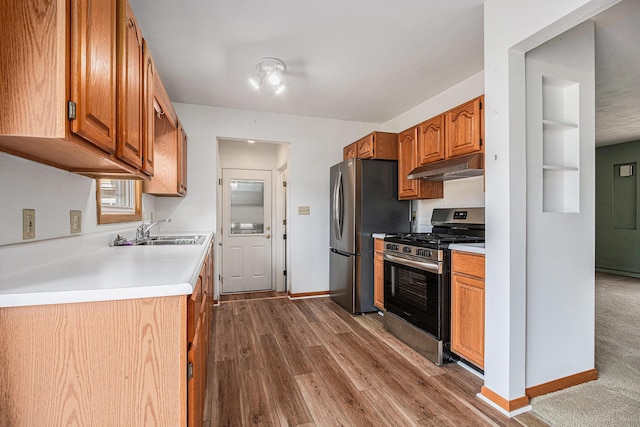 981 Vinewood Dr, Saint Joseph, MI 49085 - kitchen featuring appliances with stainless steel finishes, under cabinet range hood, wood finished floors, light countertops, and brown cabinets