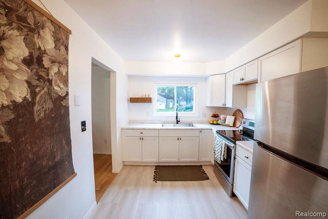 8220 Rivard Ave, Warren, MI 48089 - kitchen featuring stainless steel appliances, white cabinets, light wood-type flooring, and light countertops