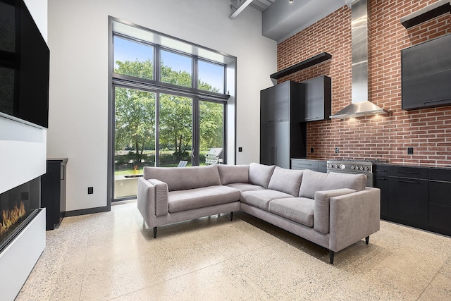 220 King St Unit 6, Lowell, MI 49331 - living room with a towering ceiling, dark aggregate flooring, and a warm lit fireplace
