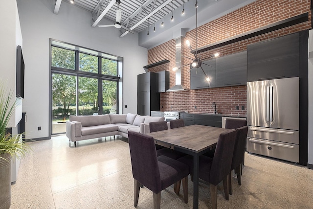 220 King St Unit 6, Lowell, MI 49331 - dining room featuring a high ceiling, brick wall, a ceiling fan, and dark speckled floor