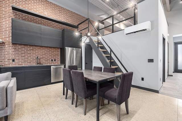220 King St Unit 6, Lowell, MI 49331 - dining area featuring a high ceiling, a wall mounted air conditioner, stairs, dark speckled floor, and brick wall