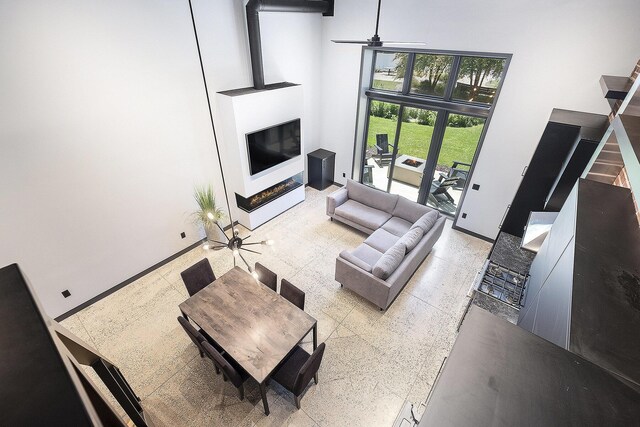220 King St Unit 6, Lowell, MI 49331 - living room with a high ceiling, a glass covered fireplace, and ceiling fan