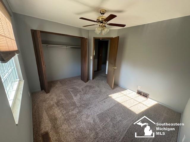 13091 Rosedale Blvd, Carleton, MI 48117 - unfurnished bedroom with carpet flooring, a closet, and a ceiling fan