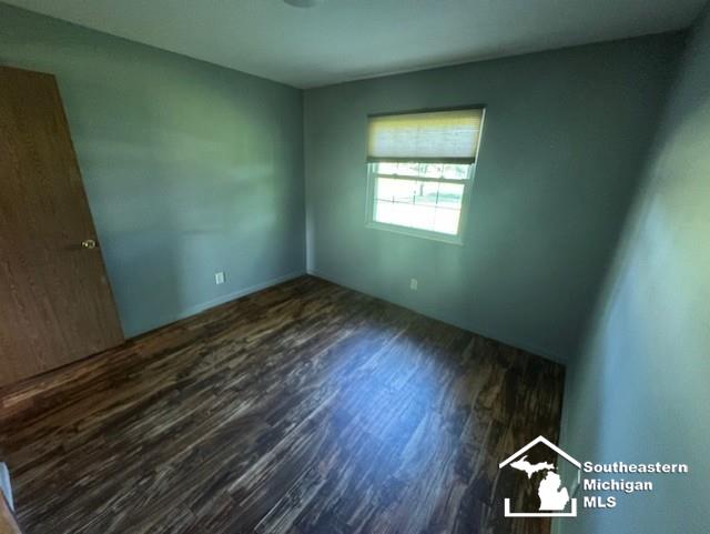 13091 Rosedale Blvd, Carleton, MI 48117 - spare room with dark wood-style flooring