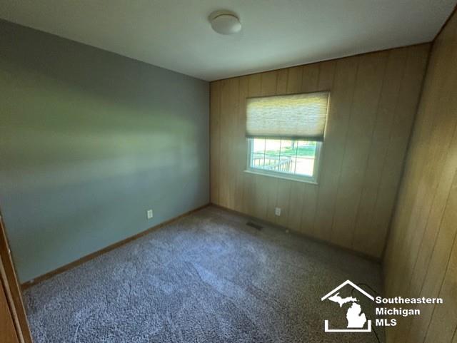 13091 Rosedale Blvd, Carleton, MI 48117 - carpeted spare room featuring wooden walls