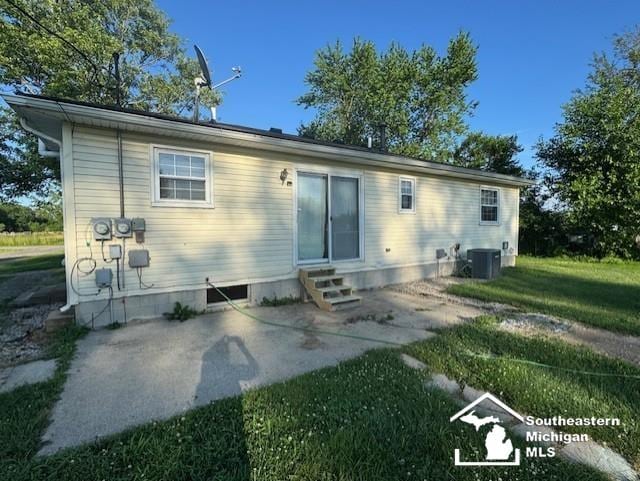 13091 Rosedale Blvd, Carleton, MI 48117 - back of house with entry steps, a patio, and a lawn