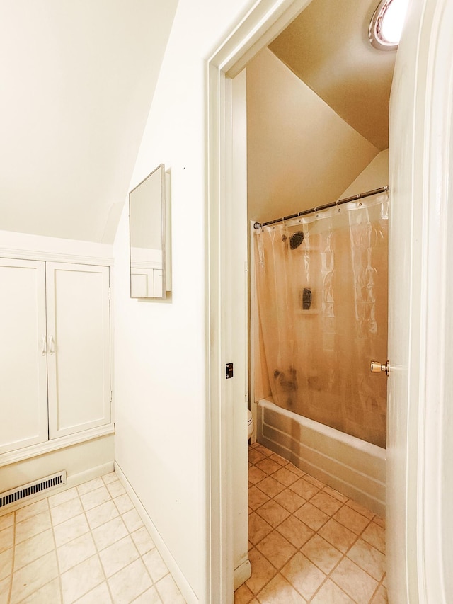 671 Lonesome Pine Trl, Saint Joseph, MI 49085 - bathroom featuring vaulted ceiling, tile patterned flooring, and shower / bath combination with curtain