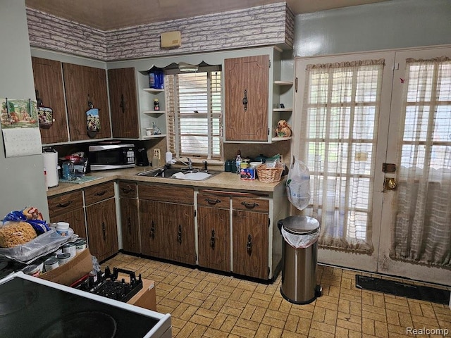 618 S Meade St, Flint, MI 48503 - kitchen with open shelves, stainless steel microwave, brick patterned floors, and light countertops