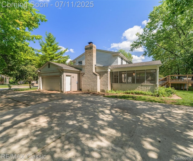 25067 Skye Dr, Farmington Hills, MI 48336 - view of front facade featuring a chimney, a sunroom, concrete driveway, an attached garage, and brick siding