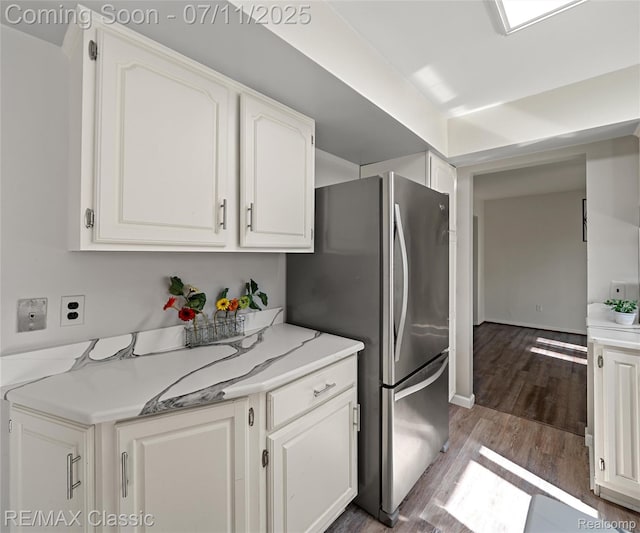 25067 Skye Dr, Farmington Hills, MI 48336 - kitchen with freestanding refrigerator, white cabinetry, wood finished floors, and light stone countertops