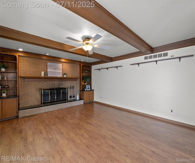 25067 Skye Dr, Farmington Hills, MI 48336 - unfurnished living room featuring beam ceiling, wood finished floors, a ceiling fan, built in features, and a brick fireplace