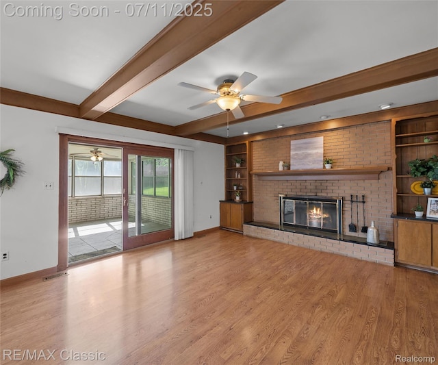 25067 Skye Dr, Farmington Hills, MI 48336 - unfurnished living room featuring a ceiling fan, built in features, light wood finished floors, beam ceiling, and a fireplace