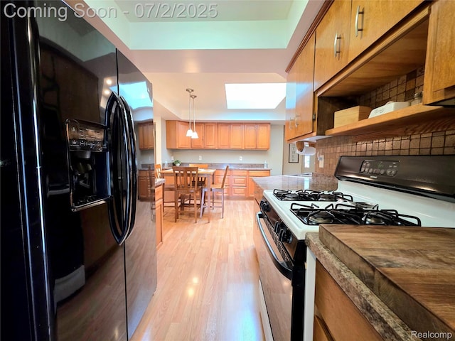 12137 Carol Ave, Warren, MI 48093 - kitchen featuring black fridge with ice dispenser, range with gas cooktop, a skylight, light wood-type flooring, and open shelves