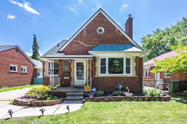17237 Philomene Blvd, Allen Park, MI 48101 - bungalow with a chimney, brick siding, a standing seam roof, a porch, and a metal roof