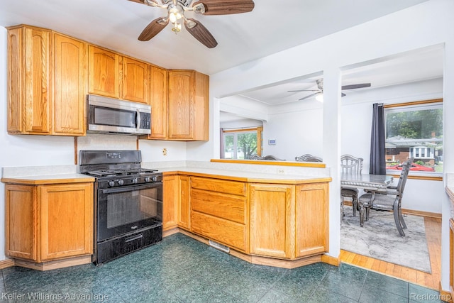 17237 Philomene Blvd, Allen Park, MI 48101 - kitchen with black gas stove, stainless steel microwave, a ceiling fan, light countertops, and a peninsula