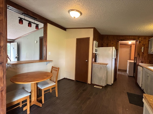 9670 Sayers Rd, Munith, MI 49259 - kitchen with a textured ceiling, freestanding refrigerator, dark wood-type flooring, dishwasher, and wooden walls