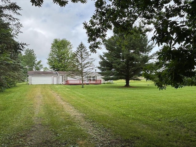 9670 Sayers Rd, Munith, MI 49259 - view of green lawn with driveway, a garage, and a deck