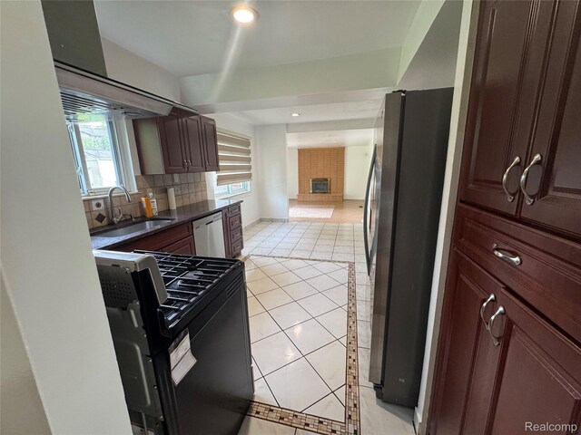 28240 Lahser Rd, Southfield, MI 48034 - kitchen featuring appliances with stainless steel finishes, dark countertops, light tile patterned floors, backsplash, and a fireplace