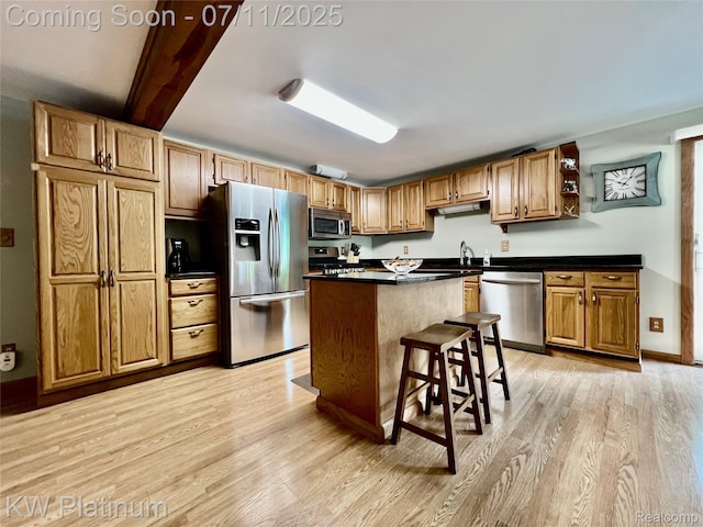 2243 Sunnyside Rd, Kimball, MI 48074 - kitchen with appliances with stainless steel finishes, light wood-style flooring, dark countertops, a kitchen island, and beam ceiling