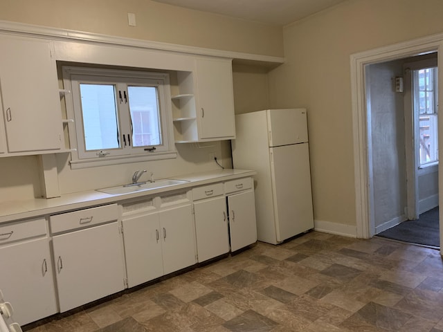 417 Oak St, Kalamazoo, MI 49007 - kitchen with open shelves, freestanding refrigerator, white cabinets, light countertops, and stone finish floors