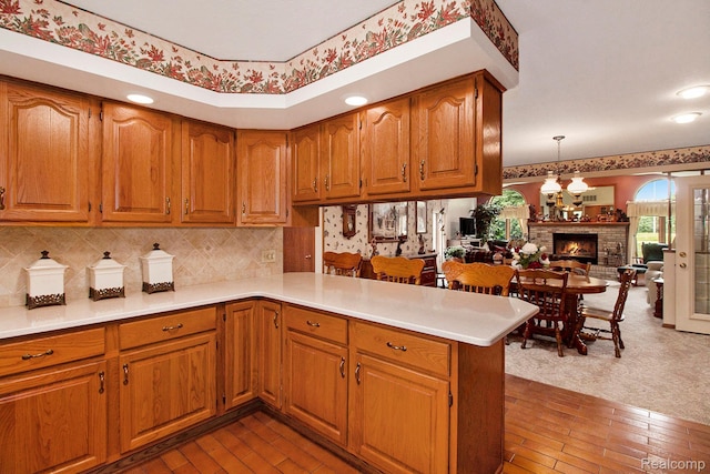 10363 E Bristol Rd, Davison, MI 48423 - kitchen featuring a peninsula, brown cabinetry, light countertops, open floor plan, and a chandelier