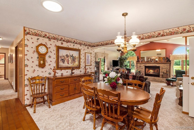 10363 E Bristol Rd, Davison, MI 48423 - dining room with light wood-style floors, a fireplace, a chandelier, and wallpapered walls