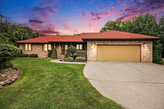 10363 E Bristol Rd, Davison, MI 48423 - ranch-style home with concrete driveway, a garage, a porch, a yard, and brick siding