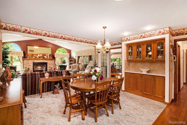 10363 E Bristol Rd, Davison, MI 48423 - dining room with wood-type flooring, a fireplace, and vaulted ceiling