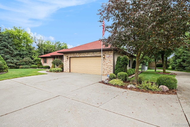 10363 E Bristol Rd, Davison, MI 48423 - view of property exterior with a garage, concrete driveway, a yard, and brick siding