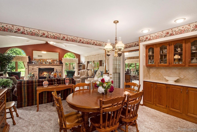 10363 E Bristol Rd, Davison, MI 48423 - dining area with lofted ceiling, light carpet, a lit fireplace, and a chandelier