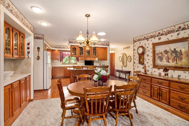 10363 E Bristol Rd, Davison, MI 48423 - dining area featuring a chandelier, wallpapered walls, and light wood-type flooring