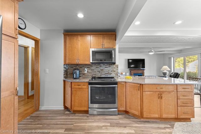 17729 Harman St, Melvindale, MI 48122 - kitchen featuring stainless steel appliances, a peninsula, light wood-style floors, ceiling fan, and decorative backsplash