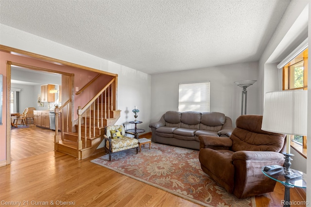 17729 Harman St, Melvindale, MI 48122 - living room with a textured ceiling, light wood-style floors, and stairway