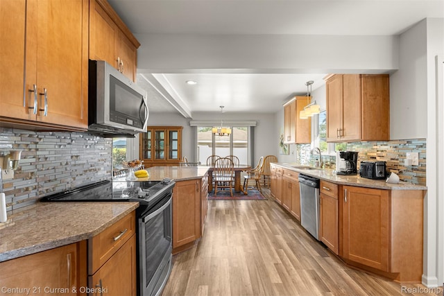 17729 Harman St, Melvindale, MI 48122 - kitchen featuring stainless steel appliances, light wood-style flooring, brown cabinetry, and decorative backsplash