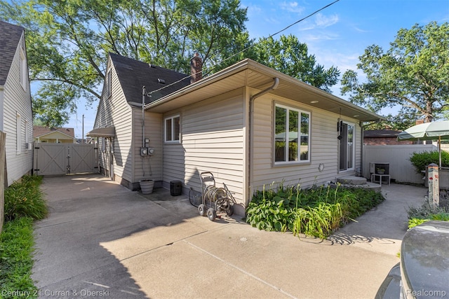 17729 Harman St, Melvindale, MI 48122 - view of side of home featuring a gate, a chimney, driveway, and a patio area