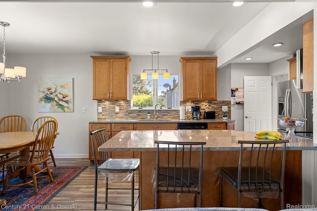 17729 Harman St, Melvindale, MI 48122 - kitchen featuring stainless steel refrigerator with ice dispenser, a kitchen breakfast bar, wood finished floors, tasteful backsplash, and recessed lighting