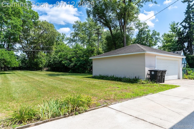 14778 Harrison St, Livonia, MI 48154 - view of grassy yard featuring concrete driveway, an outdoor structure, and a detached garage